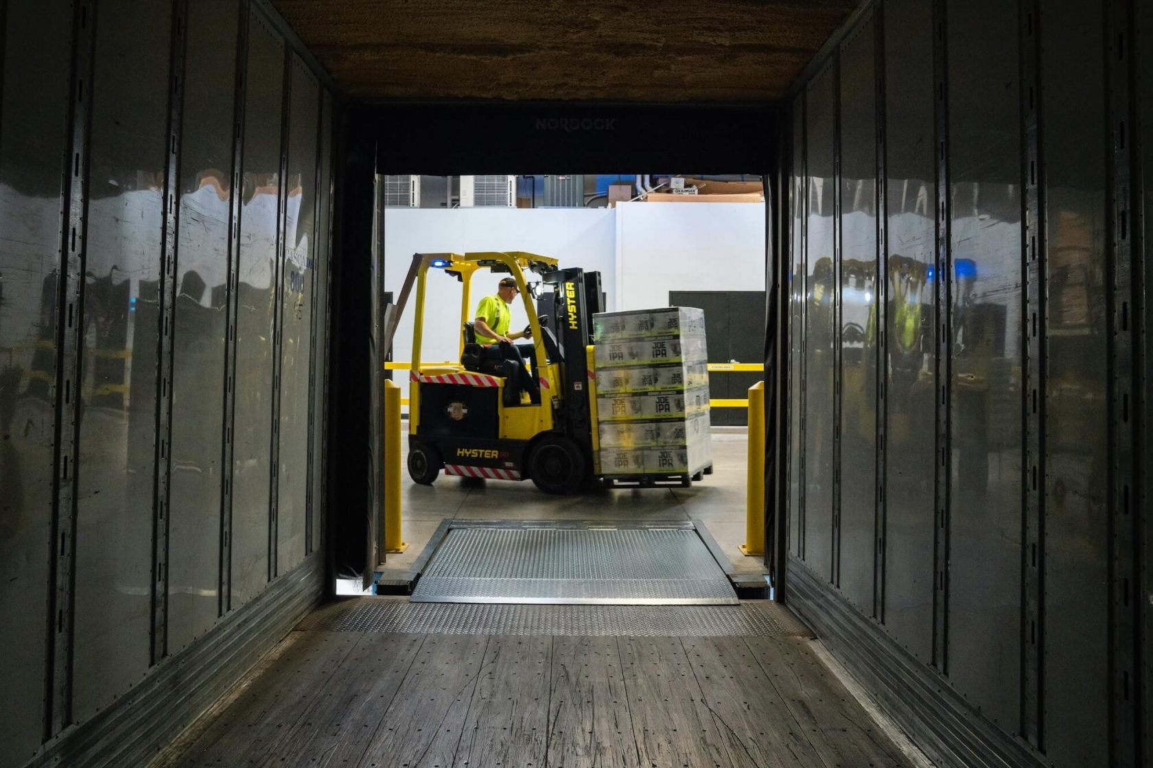 worker driving a yellow forklift