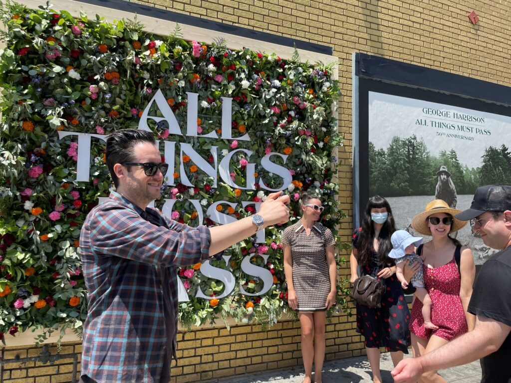 Three-dimensional living garden installation on Melrose Avenue celebrating George Harrison's 'All Things Must Pass' 50th anniversary, featuring a vibrant flower wall that honored both his music and passion for horticulture