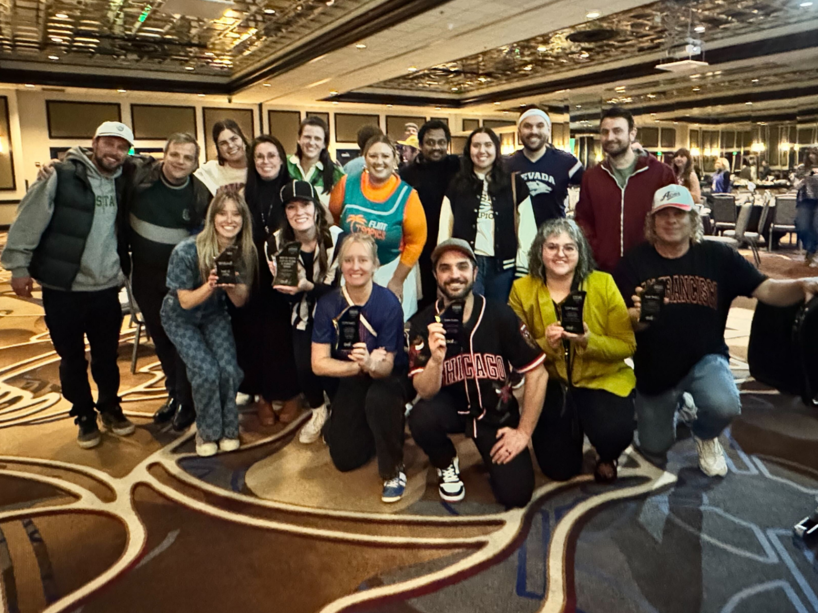 Noble Studios team members proudly displaying their nine ADDY awards, including four gold trophies and the Best of Show recognition. Team members in business casual attire stand together smiling, holding the prestigious gold and silver awards from the 2025 American Advertising Awards ceremony.