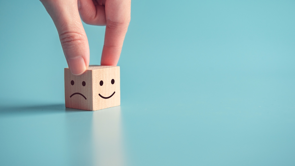 happy face and sad face wood block indicating brand intelligence outcomes